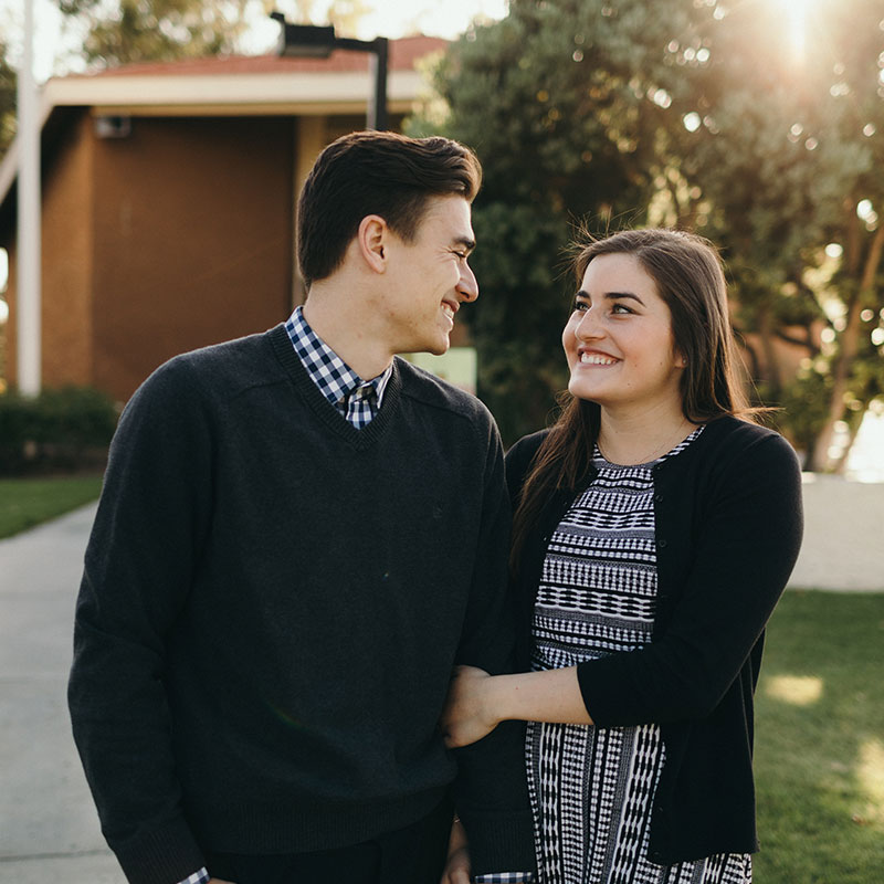 Scott and Ariana holding hands walking in front of Good Shepherd Chapel